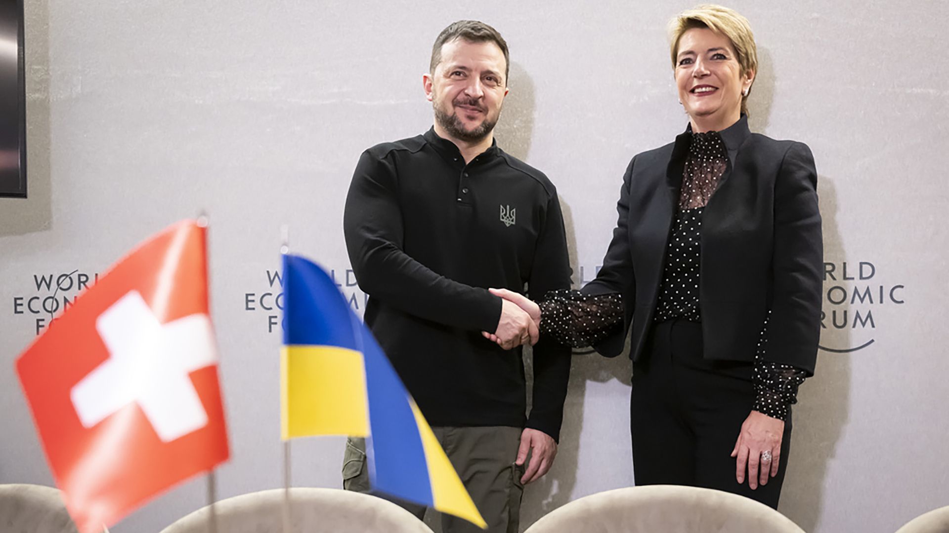 Swiss Federal President Karin Keller-Sutter, right, and Ukrainian President Volodymyr Zelenskyy, left, shake hands prior to a bilateral meeting on the sideline of the 55th annual meeting of the World Economic Forum, WEF, in Davos